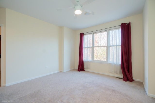 carpeted spare room featuring ceiling fan