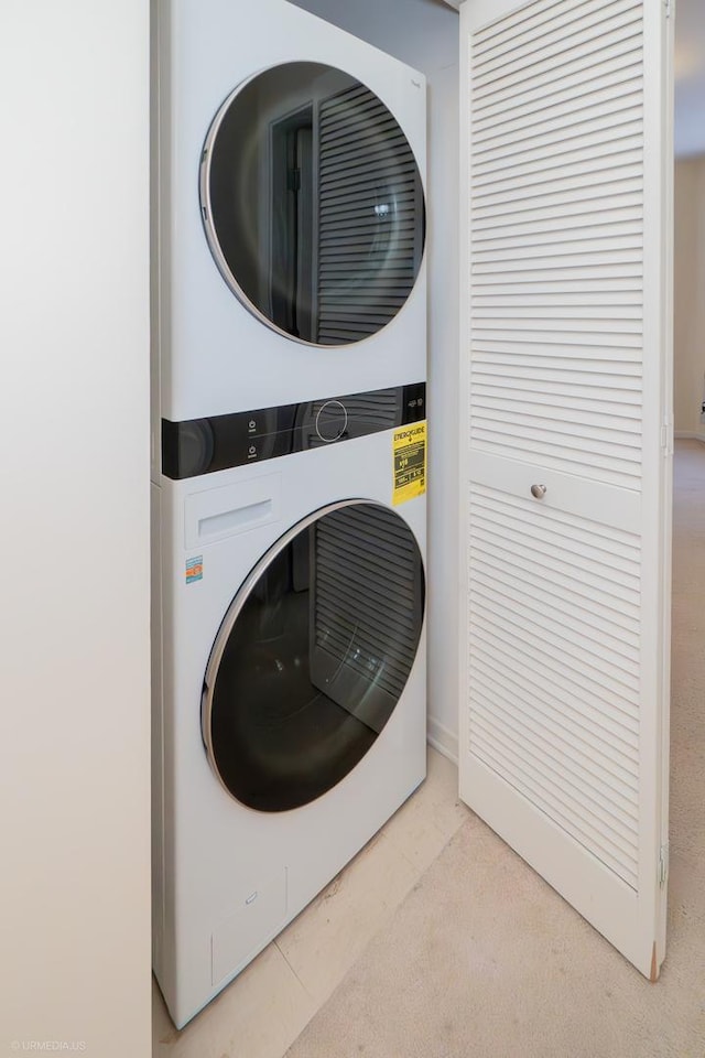 clothes washing area featuring stacked washer and dryer