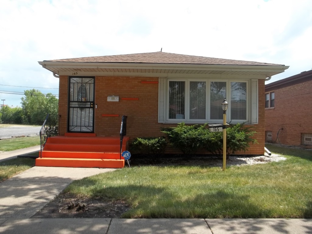 bungalow-style home with a front lawn