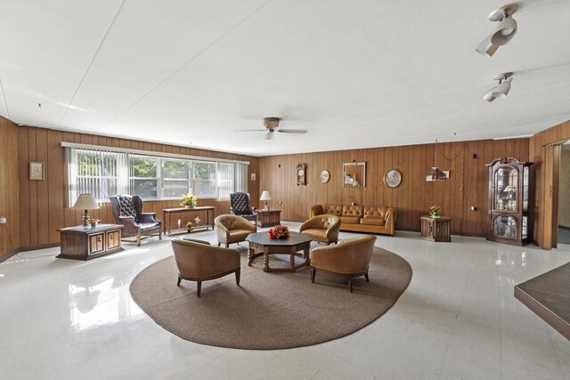 living room with wood walls and ceiling fan