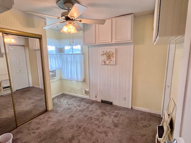 unfurnished dining area with ceiling fan, cooling unit, and carpet floors