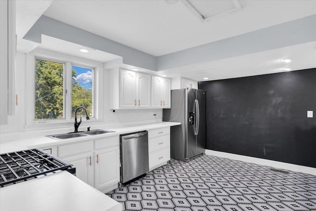 kitchen featuring appliances with stainless steel finishes, sink, and white cabinetry