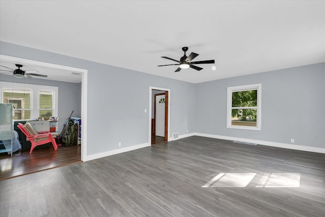 empty room with ceiling fan and dark hardwood / wood-style flooring