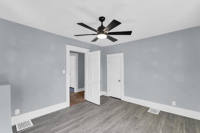 unfurnished bedroom with ceiling fan and hardwood / wood-style floors