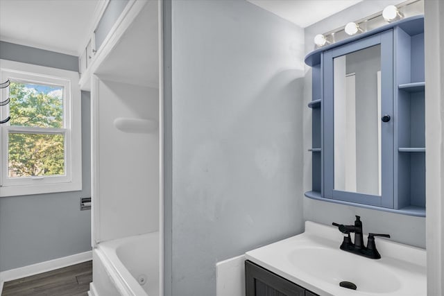 bathroom with wood-type flooring, vanity, and a tub