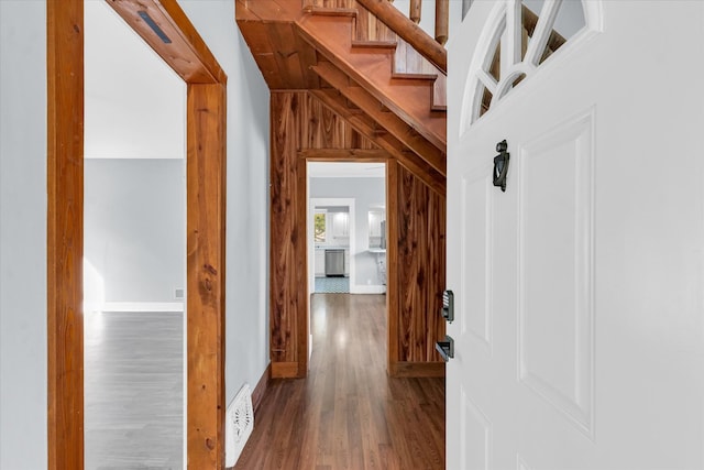 corridor featuring wood walls and dark wood-type flooring