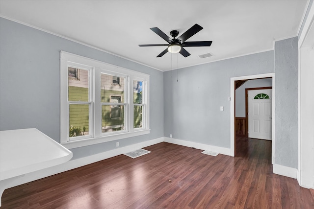 empty room with ceiling fan, dark hardwood / wood-style floors, and ornamental molding