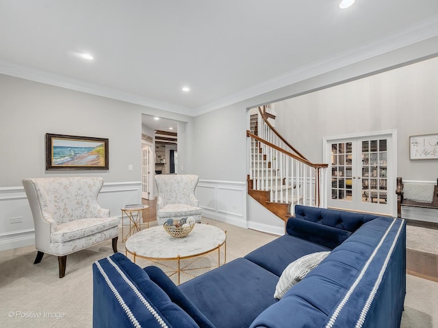 living room featuring french doors, crown molding, and light carpet