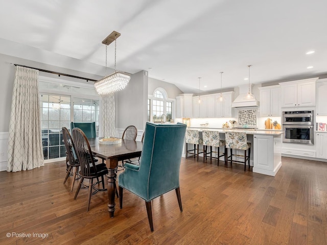 dining area featuring lofted ceiling and dark hardwood / wood-style floors