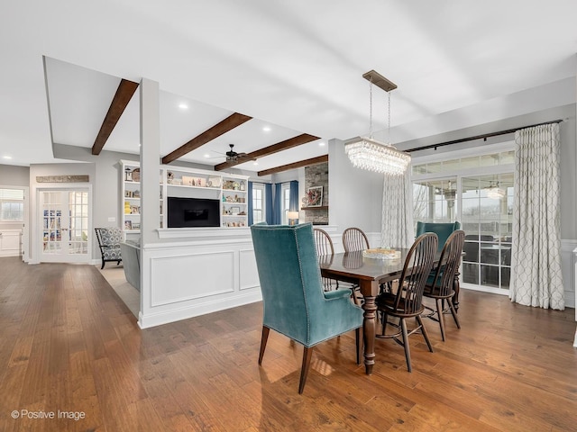 dining room featuring hardwood / wood-style flooring, ceiling fan, and beamed ceiling