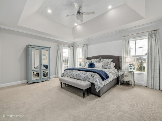 carpeted bedroom with a tray ceiling and ceiling fan