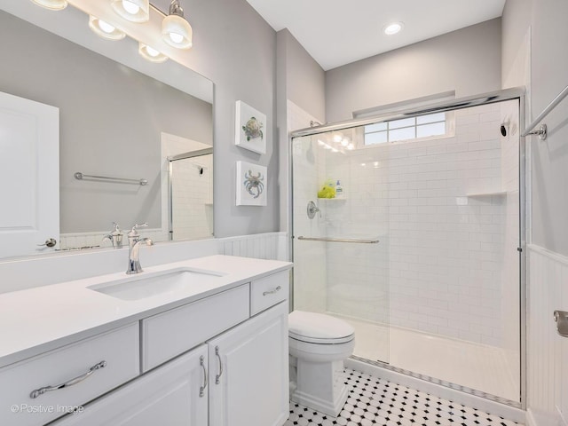 bathroom featuring vanity, an enclosed shower, and toilet