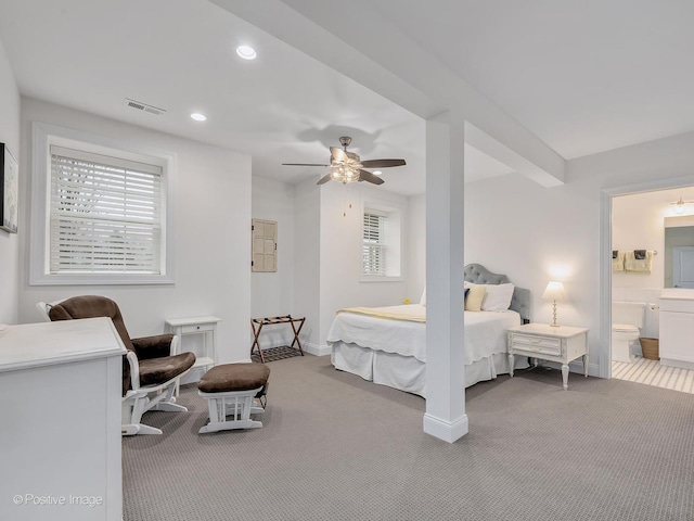 carpeted bedroom with ensuite bathroom and ceiling fan