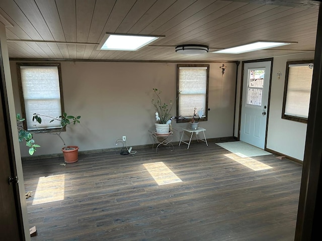 interior space featuring wood ceiling, a skylight, dark hardwood / wood-style floors, and crown molding