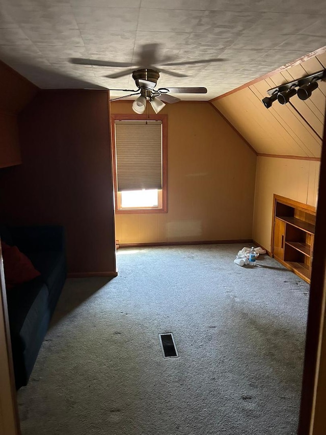 bonus room with a textured ceiling, carpet flooring, vaulted ceiling, and ceiling fan