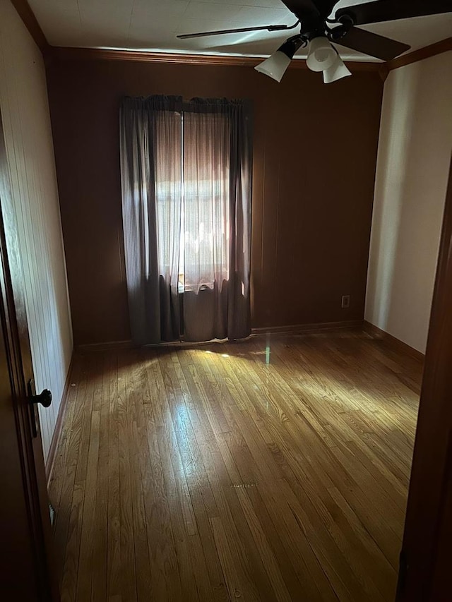 empty room with ceiling fan and hardwood / wood-style floors