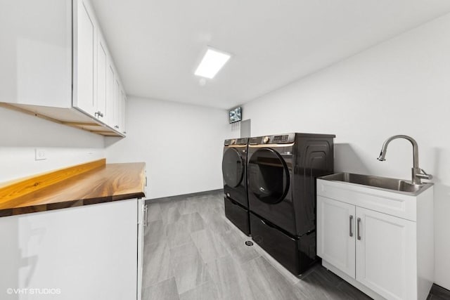 laundry area with cabinets, separate washer and dryer, and sink