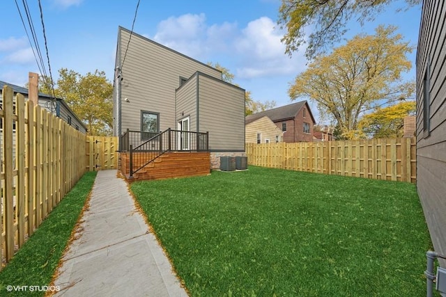 back of house featuring a lawn and central air condition unit