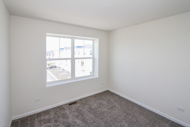 empty room with dark colored carpet