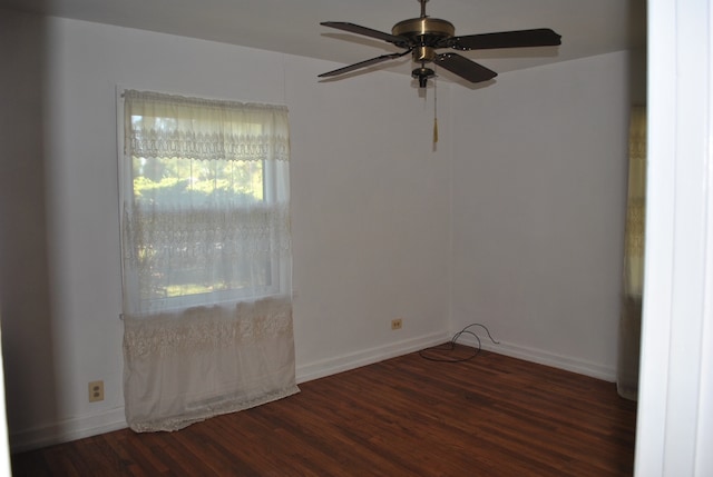 spare room with dark wood-type flooring and ceiling fan