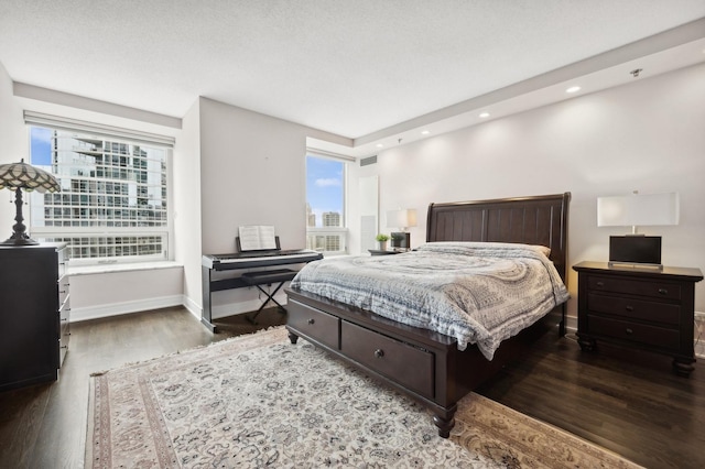 bedroom with dark hardwood / wood-style flooring and multiple windows