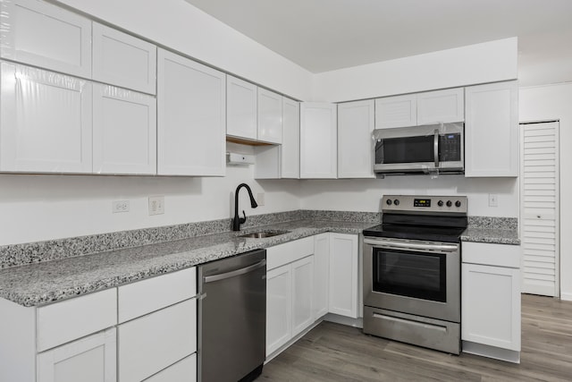 kitchen featuring dark hardwood / wood-style flooring, stainless steel appliances, white cabinetry, and sink