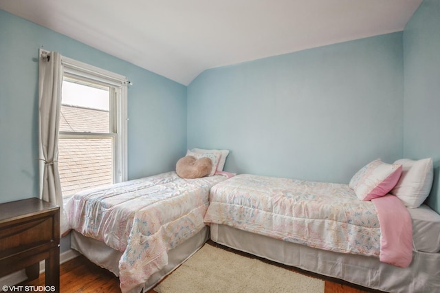 bedroom featuring lofted ceiling and hardwood / wood-style floors