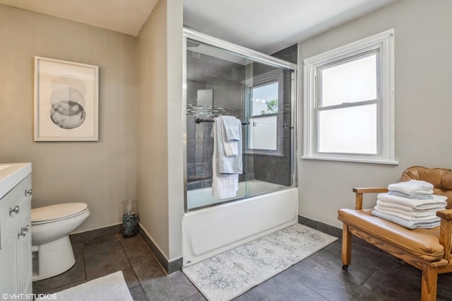 full bathroom featuring toilet, vanity, and bath / shower combo with glass door