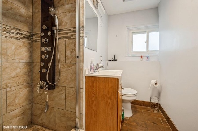 bathroom with vanity, a tile shower, and toilet