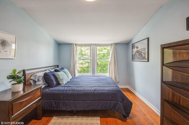 bedroom featuring wood-type flooring and vaulted ceiling