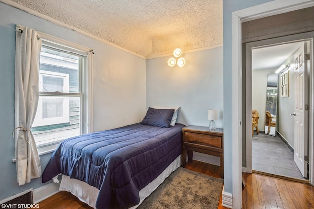 bedroom with hardwood / wood-style flooring and a textured ceiling