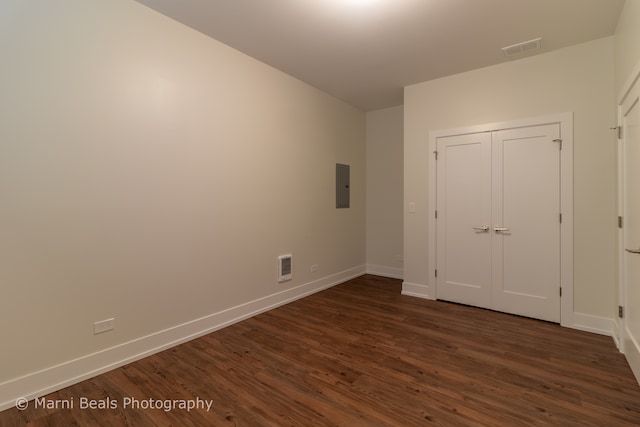 unfurnished bedroom featuring electric panel, a closet, and dark hardwood / wood-style floors