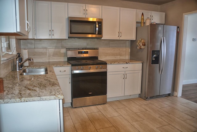 kitchen featuring white cabinetry, sink, tasteful backsplash, and appliances with stainless steel finishes