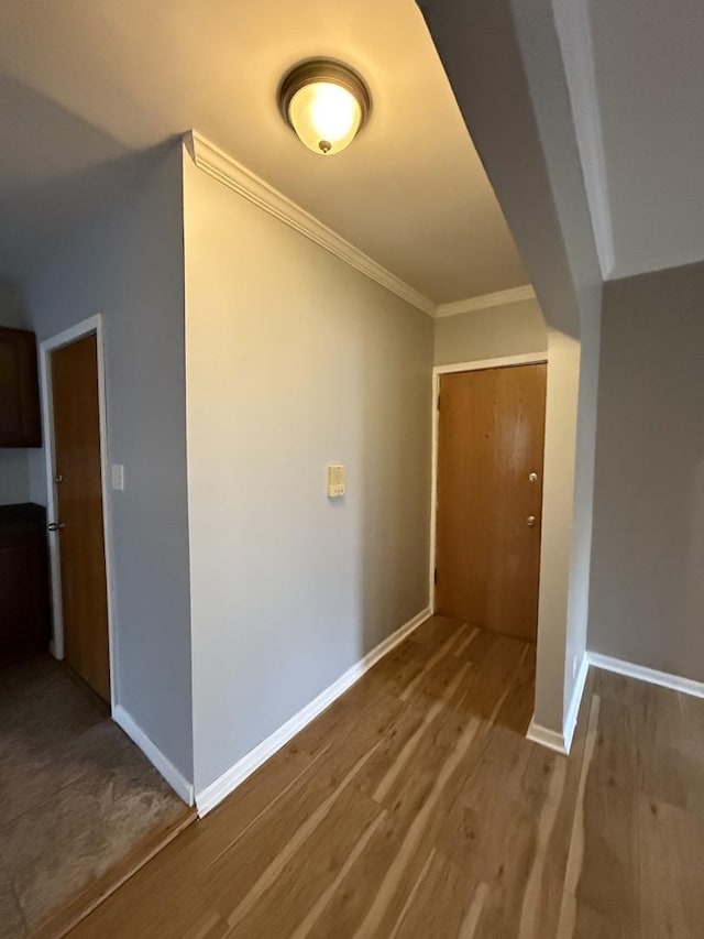 corridor with crown molding and hardwood / wood-style floors