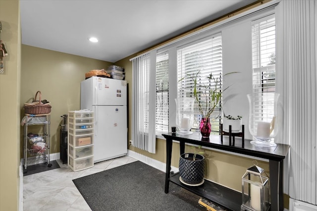 interior space with plenty of natural light, light tile patterned floors, and white refrigerator