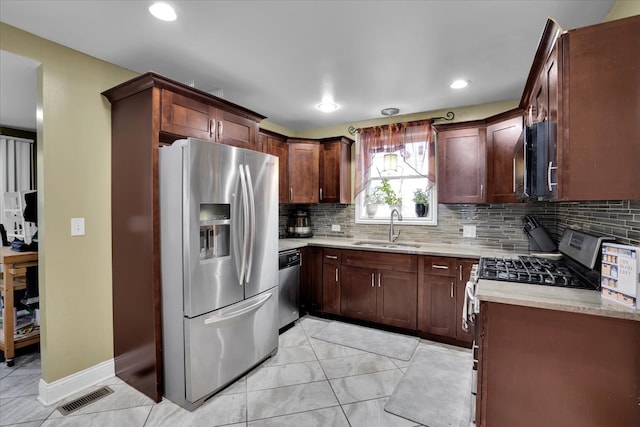 kitchen with decorative backsplash, stainless steel appliances, light stone countertops, and sink