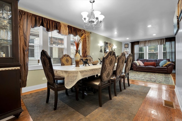 dining room with hardwood / wood-style floors and a chandelier