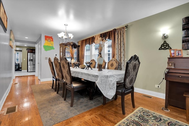 dining area featuring a notable chandelier and wood-type flooring