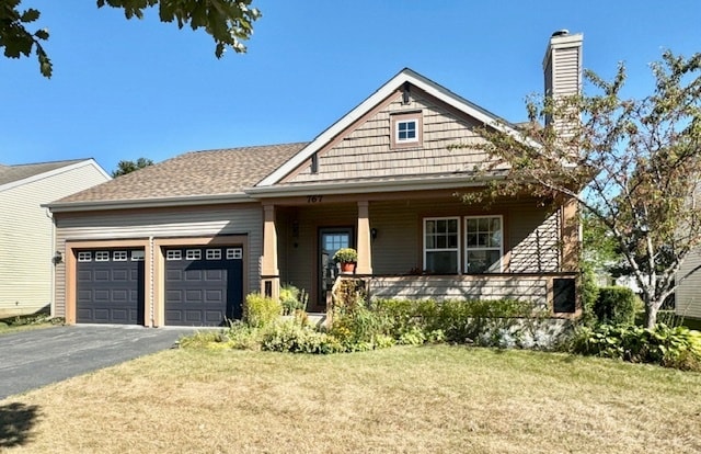 view of front facade with a garage, a front lawn, and covered porch