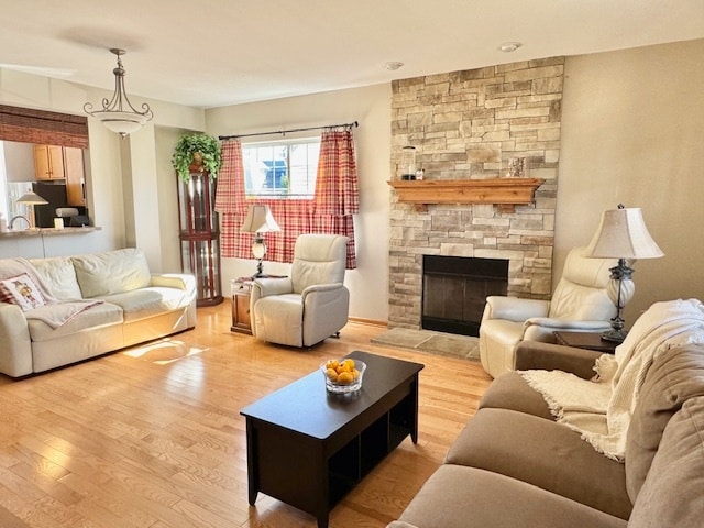 living room featuring light wood-type flooring and a fireplace