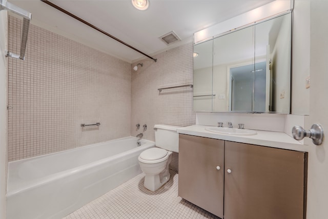 full bathroom featuring tile patterned floors, toilet, vanity, and tiled shower / bath combo