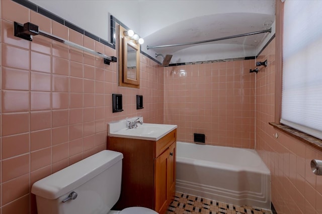 full bathroom featuring tile walls, vanity, tile patterned flooring, toilet, and tiled shower / bath