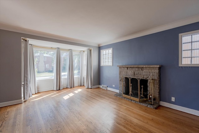 unfurnished living room with light wood-type flooring, a fireplace, and ornamental molding