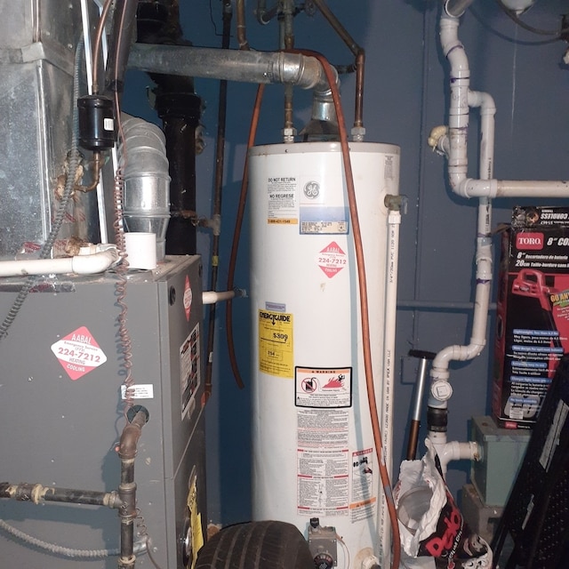 utility room featuring heating unit and water heater