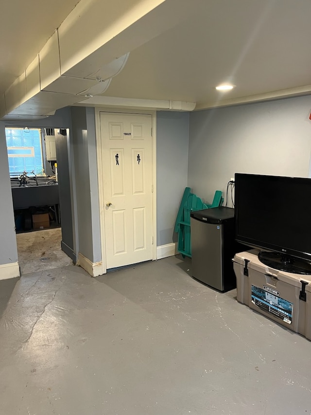 basement featuring stainless steel refrigerator