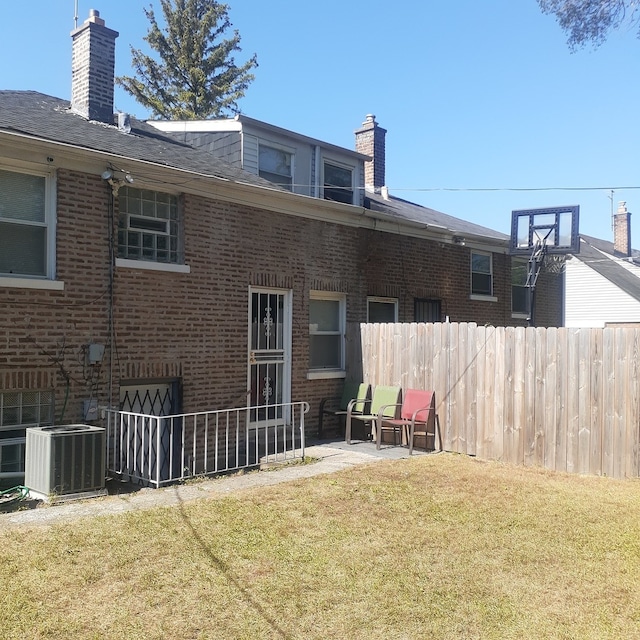 rear view of house featuring cooling unit, a yard, and a patio area