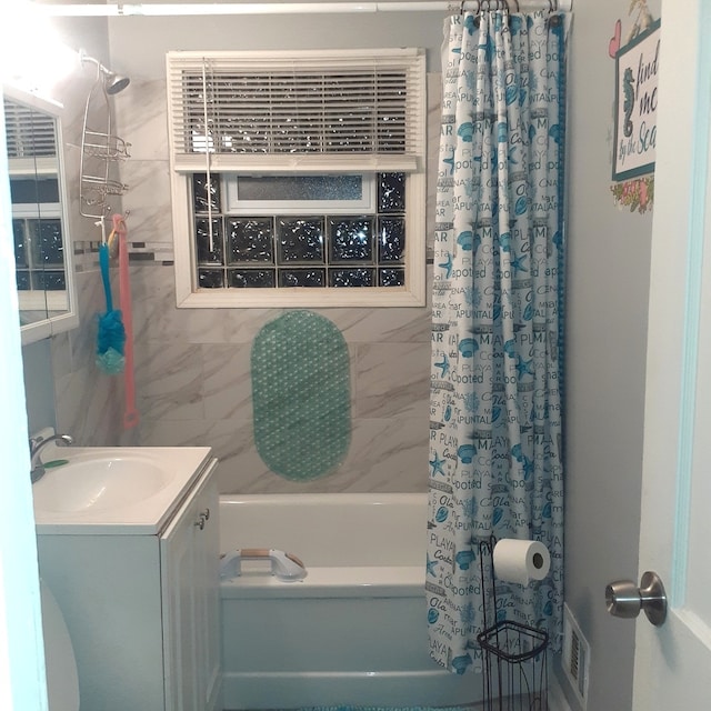 bathroom featuring shower / tub combo and vanity