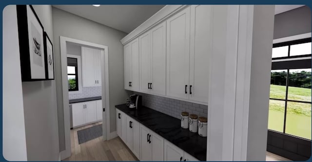 kitchen with a healthy amount of sunlight, white cabinetry, and decorative backsplash