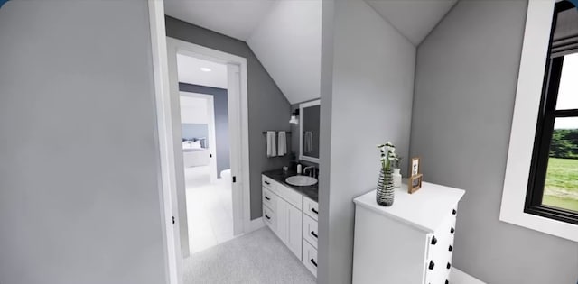 bathroom featuring vaulted ceiling and vanity