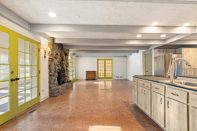 kitchen featuring plenty of natural light, sink, and a wood stove